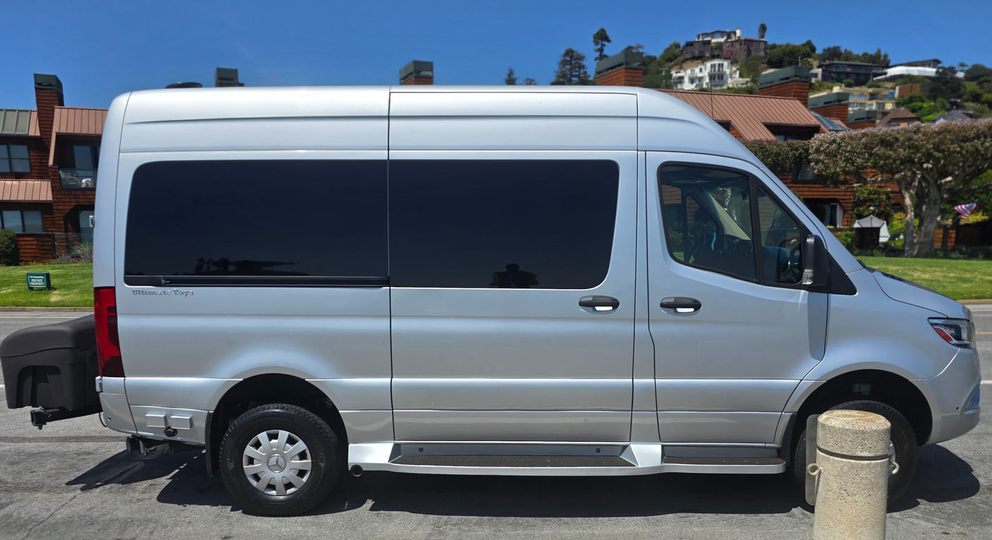 A silver Mercedes Sprinter RV rental with tinted windows and a rear cargo box, ready for adventure.