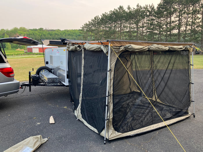 This rv rental setup features a compact travel trailer with an expansive screen room, perfect for outdoor camping comfort.