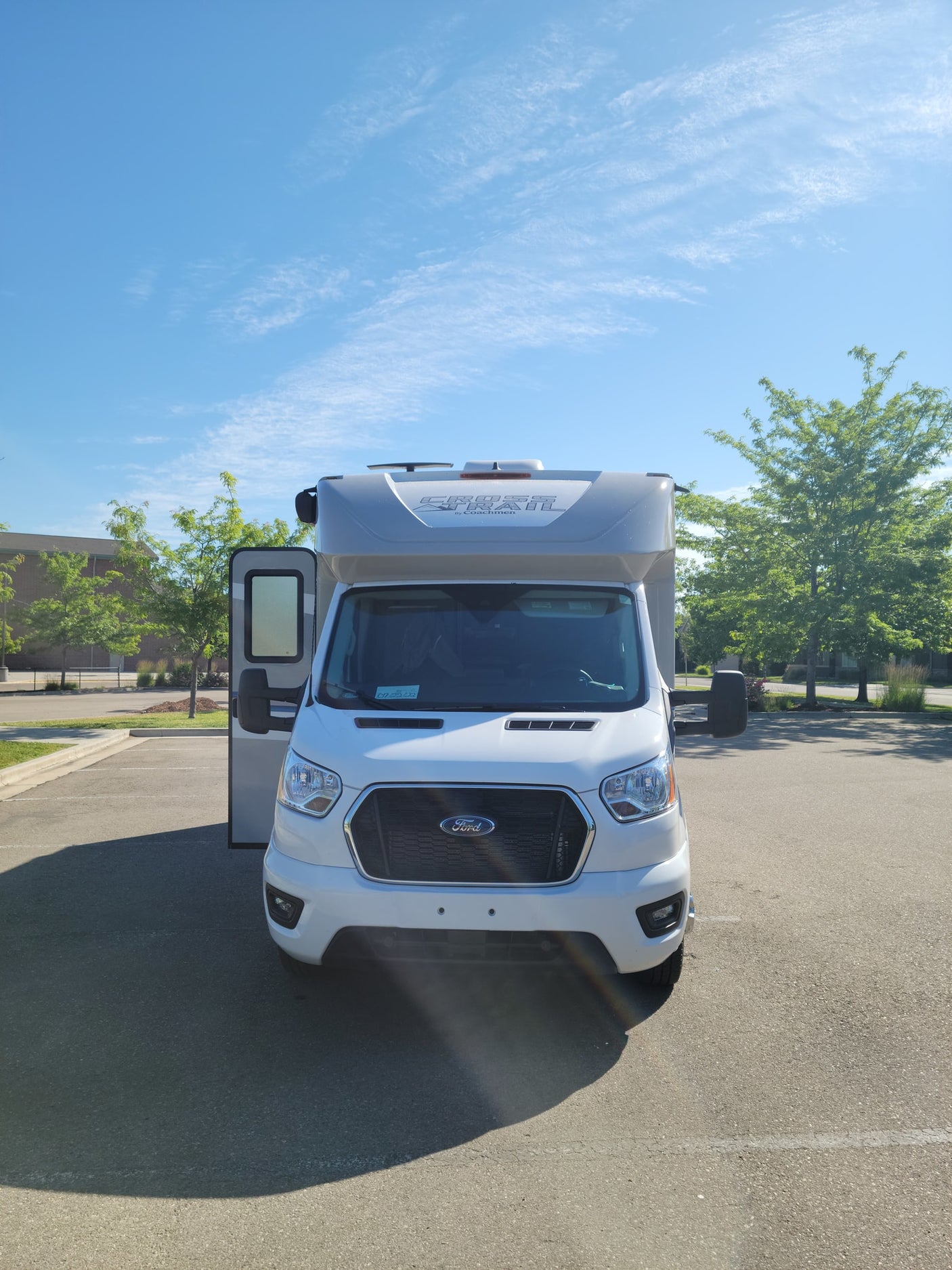 Bright white Class C RV rental (Coachmen Cross Trail on Ford chassis) parked in a sunny lot, ready for your camper adventure.