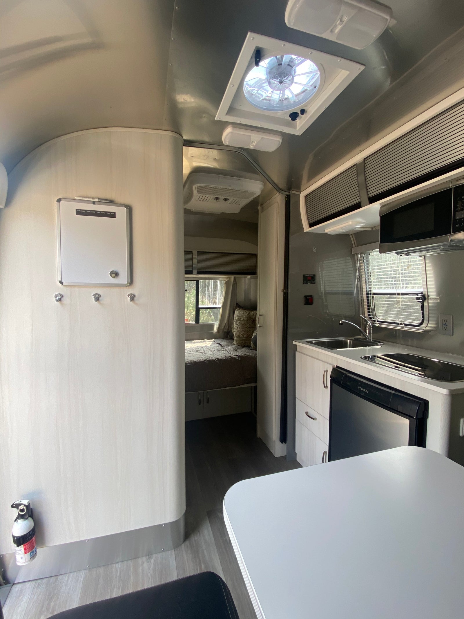Modern Airstream RV rental interior features a kitchen, bedroom, and dining area, ready for adventure.