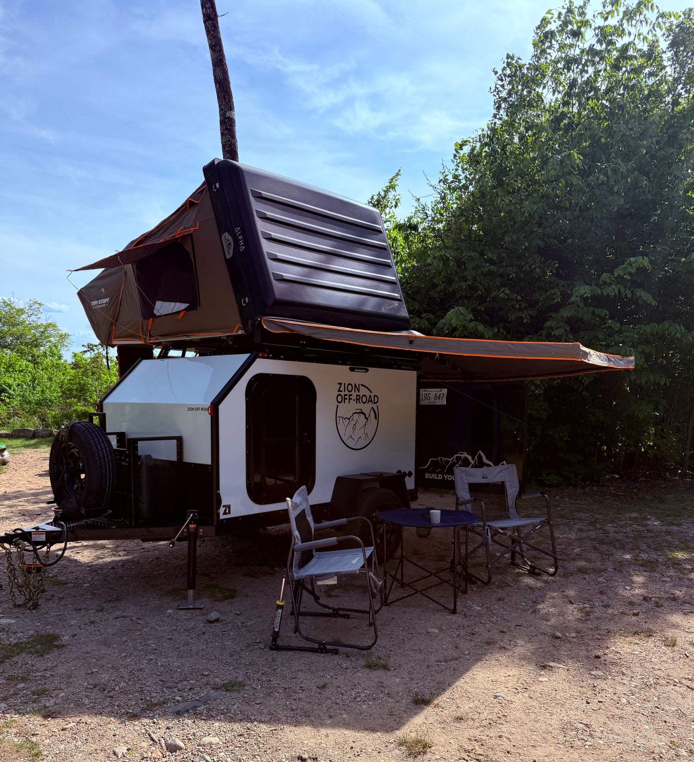 Experience outdoor adventure with this off-road teardrop rv rental trailer, featuring a roof-top tent and awning for comfortable camping.