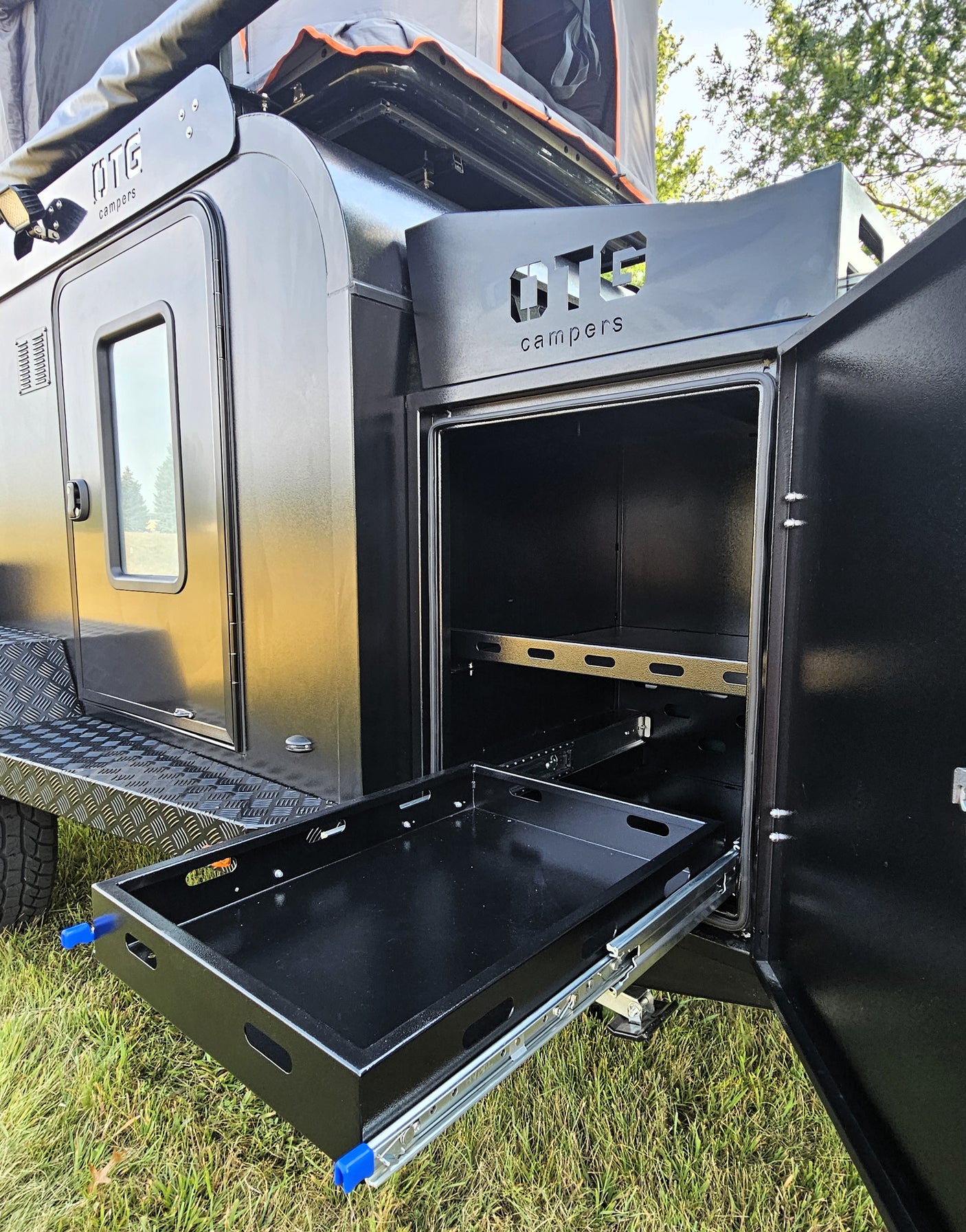 a convenient feature for your rv rental.|Black off-road camper trailer with awning & rooftop tent