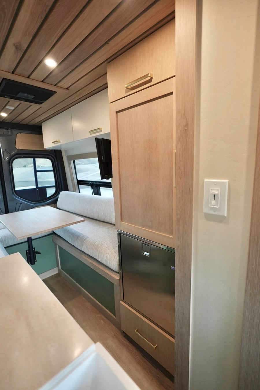 and a desert view from the window.|Rear doors of a gray camper van are open