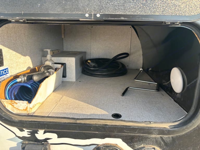and a door to nature.|Bright RV rental interior with white seating
