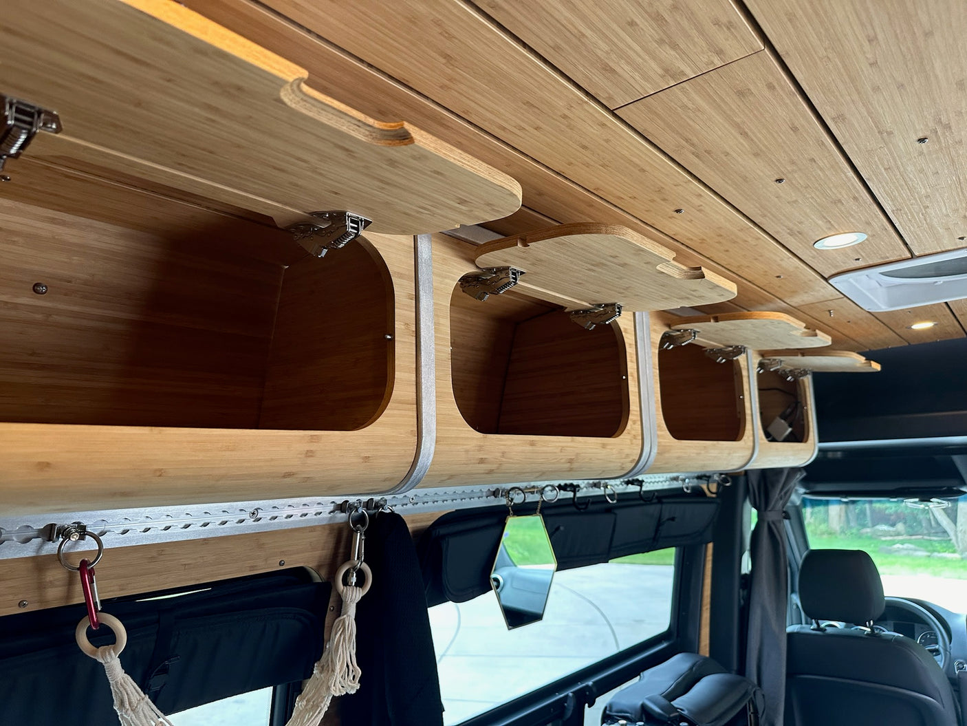 Custom bamboo overhead storage and ceiling in an RV rental, showing compact interior design.