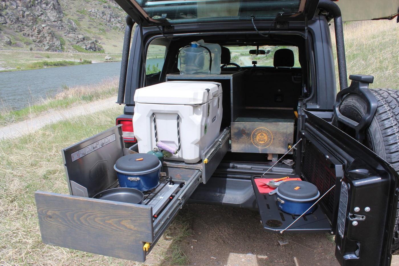 This rv rental Jeep's overlanding setup: cooler, pull-out camp kitchen, cooking station, ready for river adventures. — photo 4