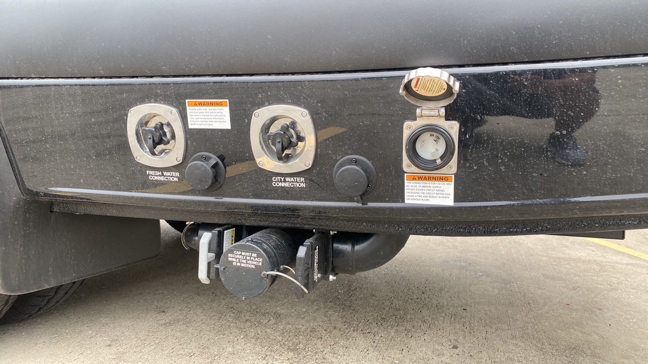 RV rental utility panel: fresh water, city water, 30A power, and waste drain connections for full hookups.
