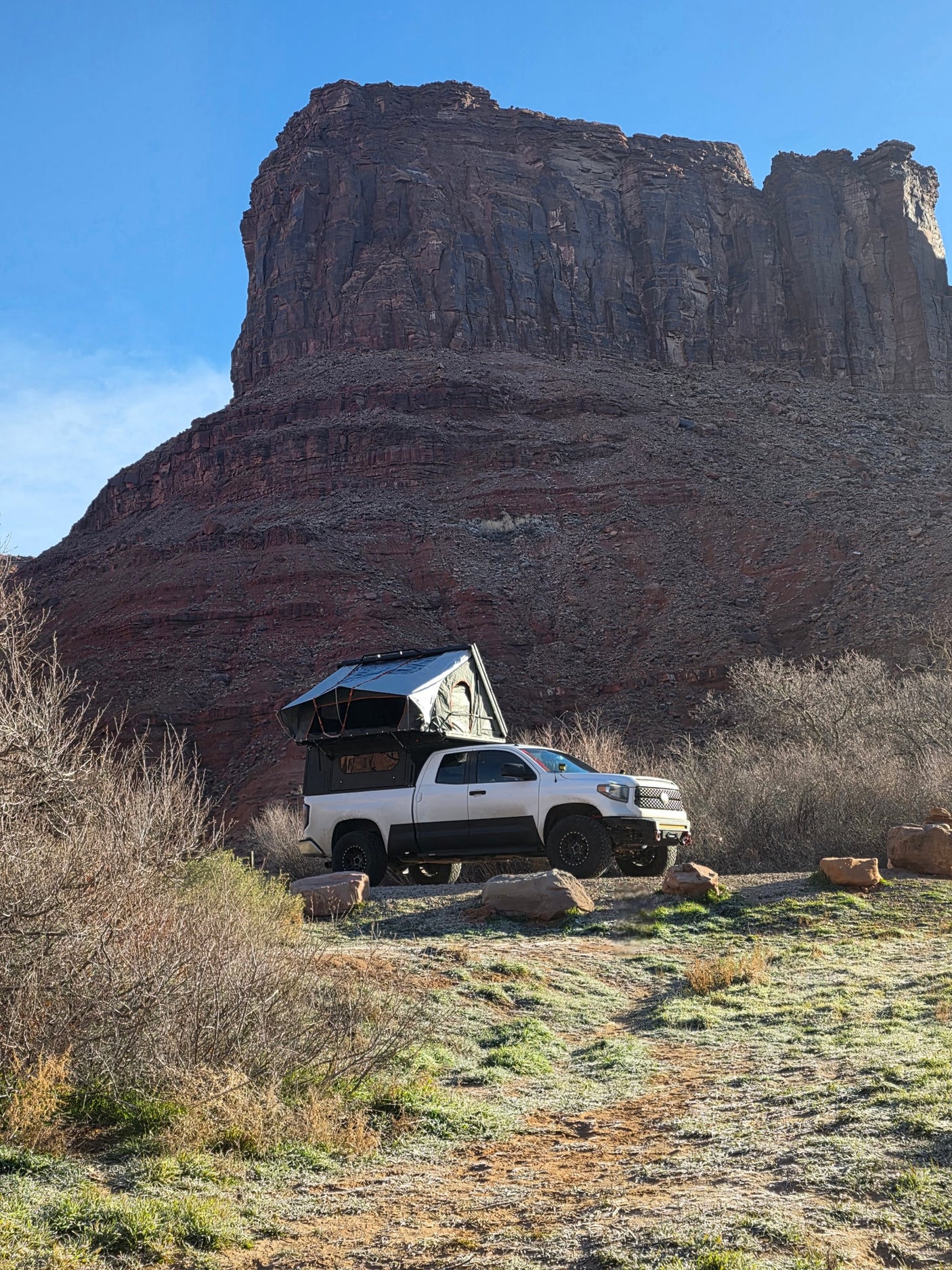 Arizona.|White Toyota Tundra overlanding rig with a truck camper on a snowy road