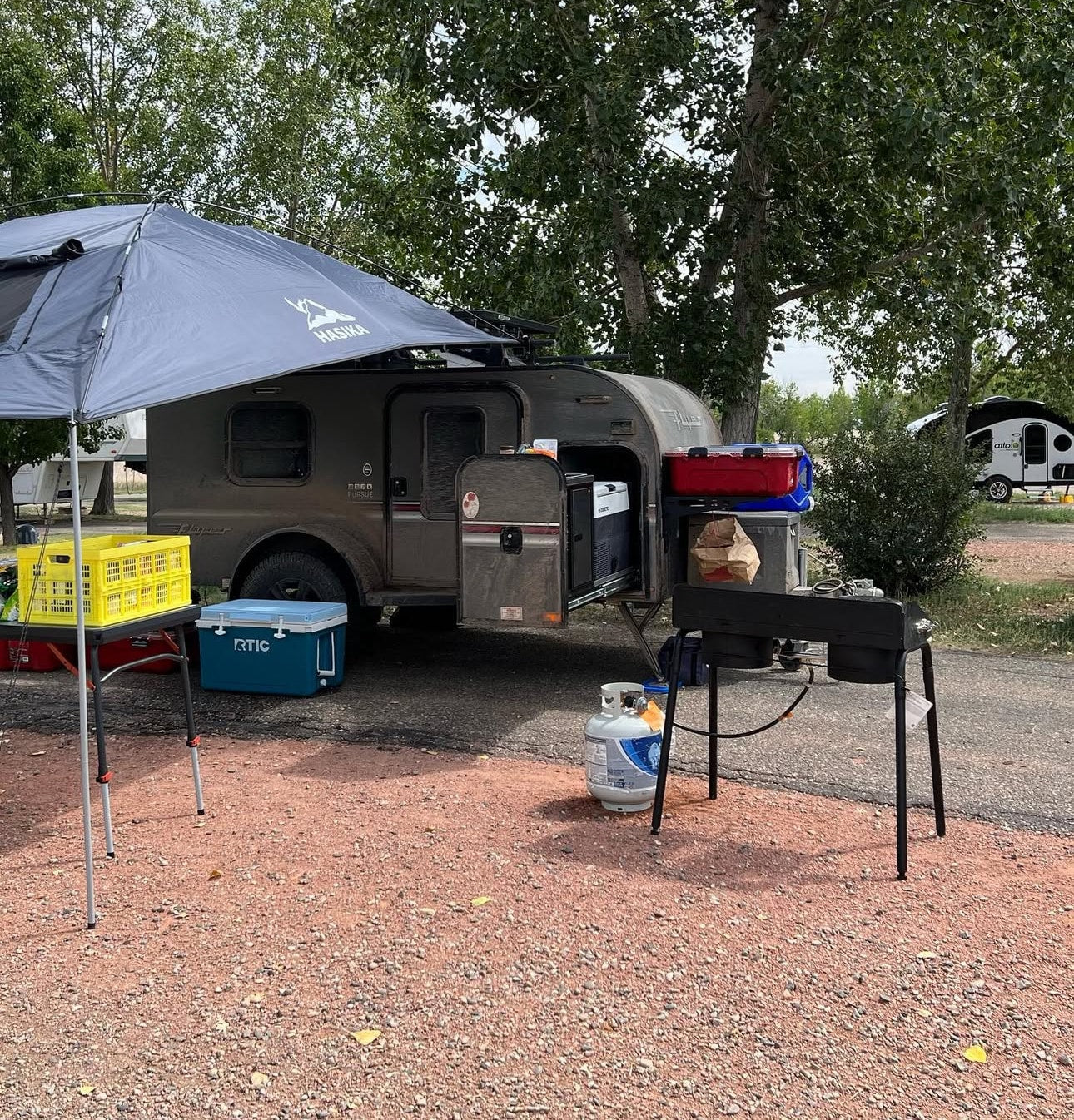 An RV rental campsite with a compact trailer