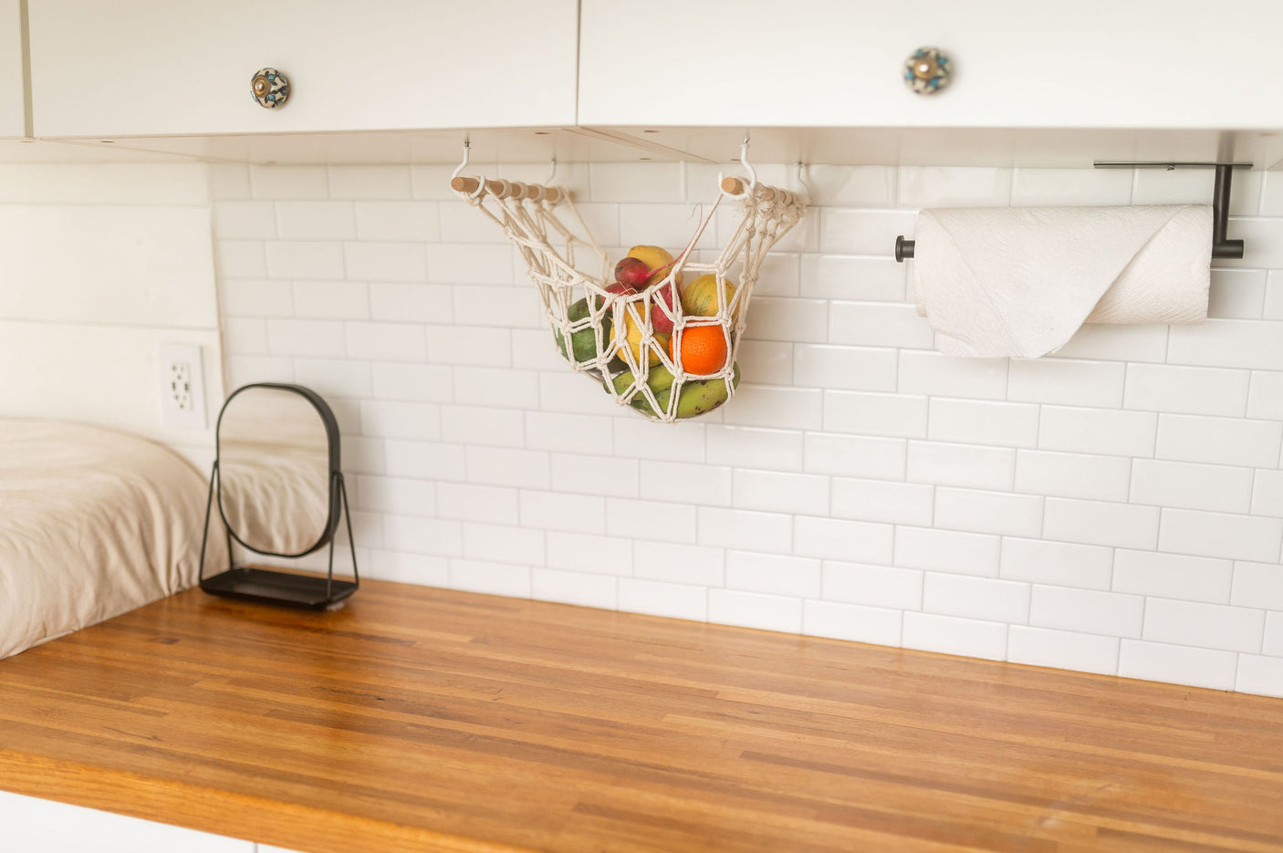 Smart RV rental kitchen design: hanging fruit storage, wood counters, and subway tile backsplash create an organized space.