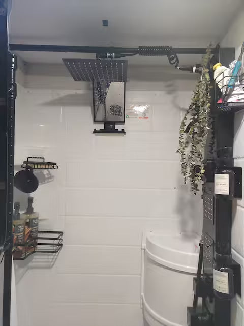 Enjoy a modern RV rental shower! Features a rain shower, handheld, and organized shelves for toiletries.