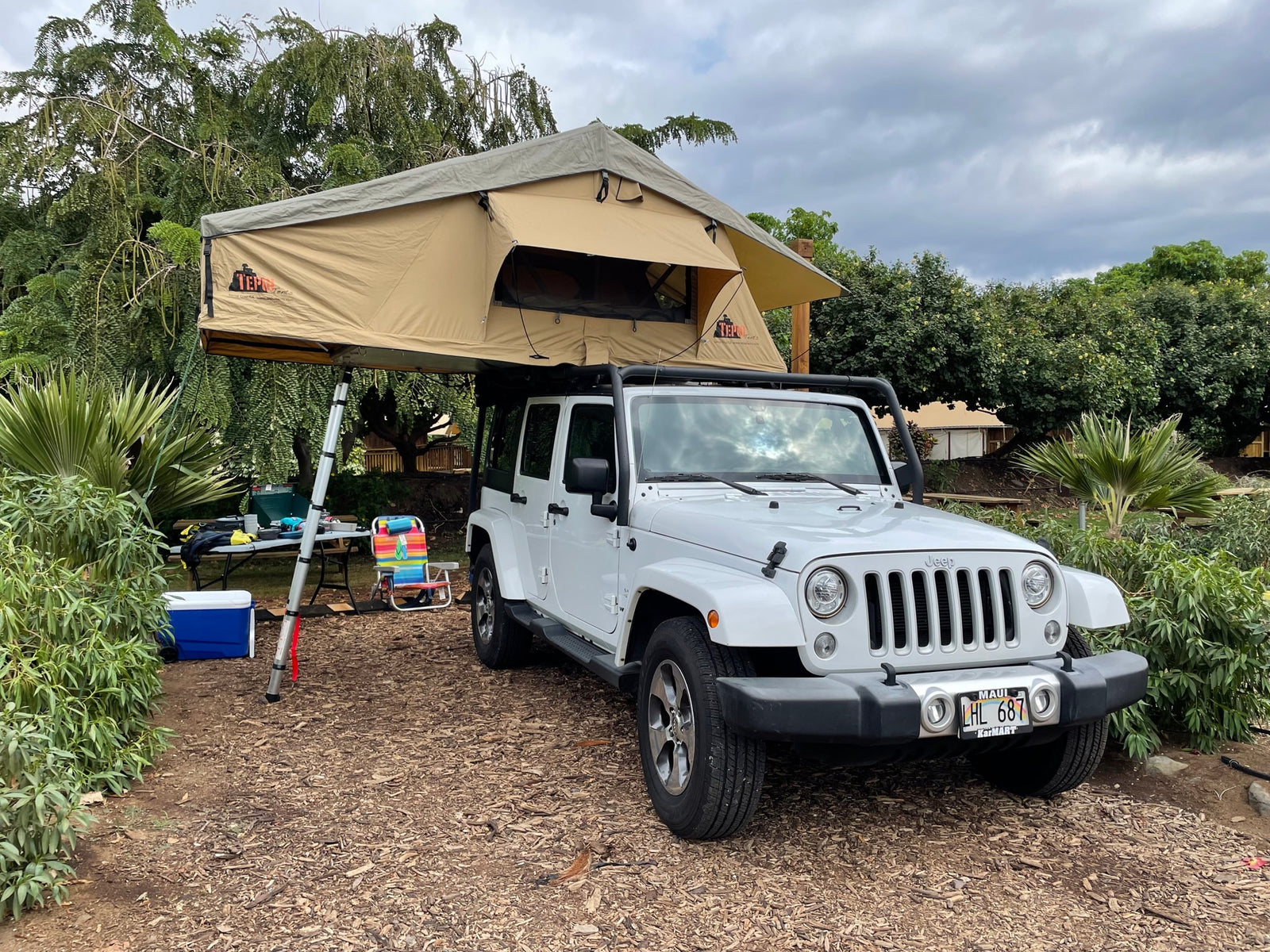 White Jeep Wrangler with a TEPUI rooftop tent deployed for camping. An excellent rv rental alternative for Maui overland adventures.