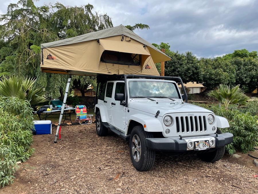 White Jeep Wrangler with a TEPUI rooftop tent deployed for camping. An excellent rv rental alternative for Maui overland adventures.
