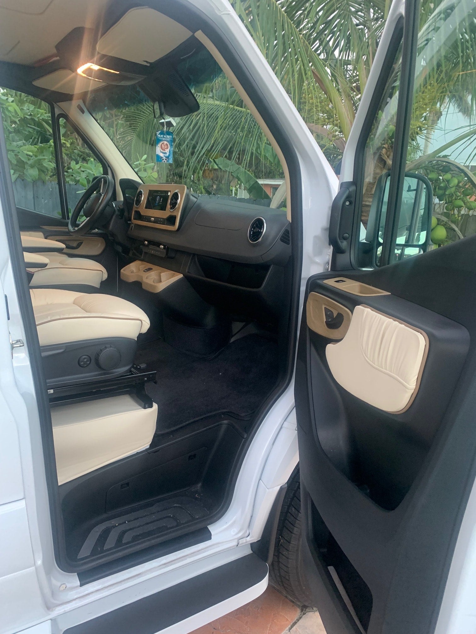 beside a white Sprinter RV rental. Adventure awaits!|RV rental: View of a modern camper van's custom interior with bed