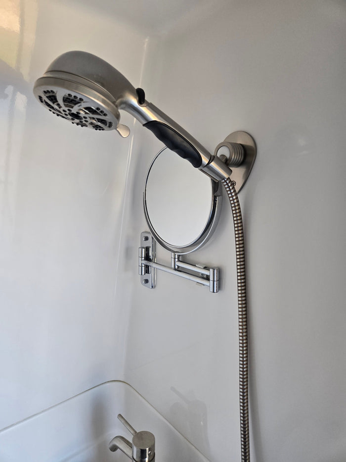 parked on concrete under a clear blue sky.|RV rental's compact bathroom showing a shower