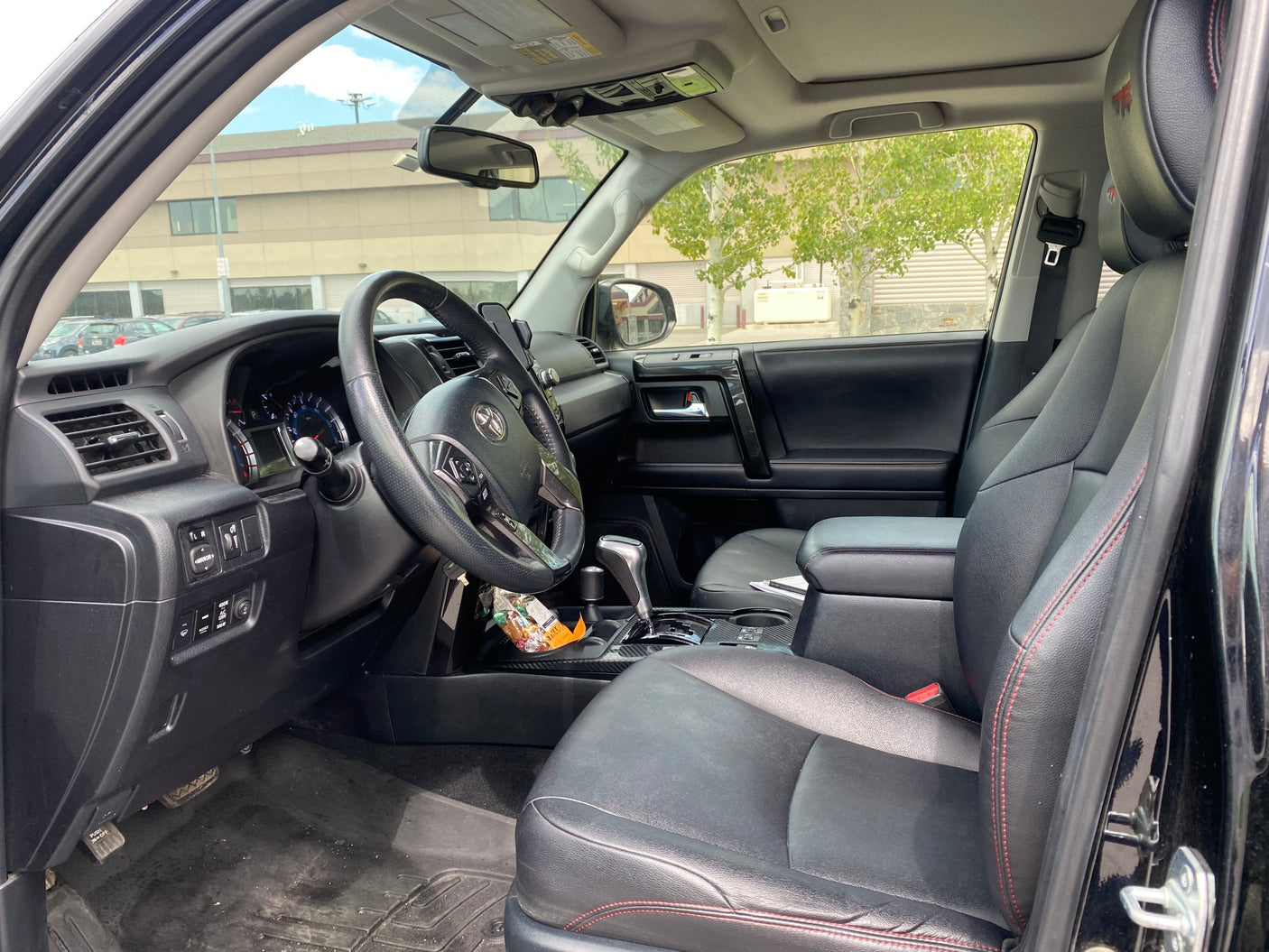The spacious interior of a vehicle, an ideal choice for an RV rental. Shows black leather seats, steering wheel, and dashboard.