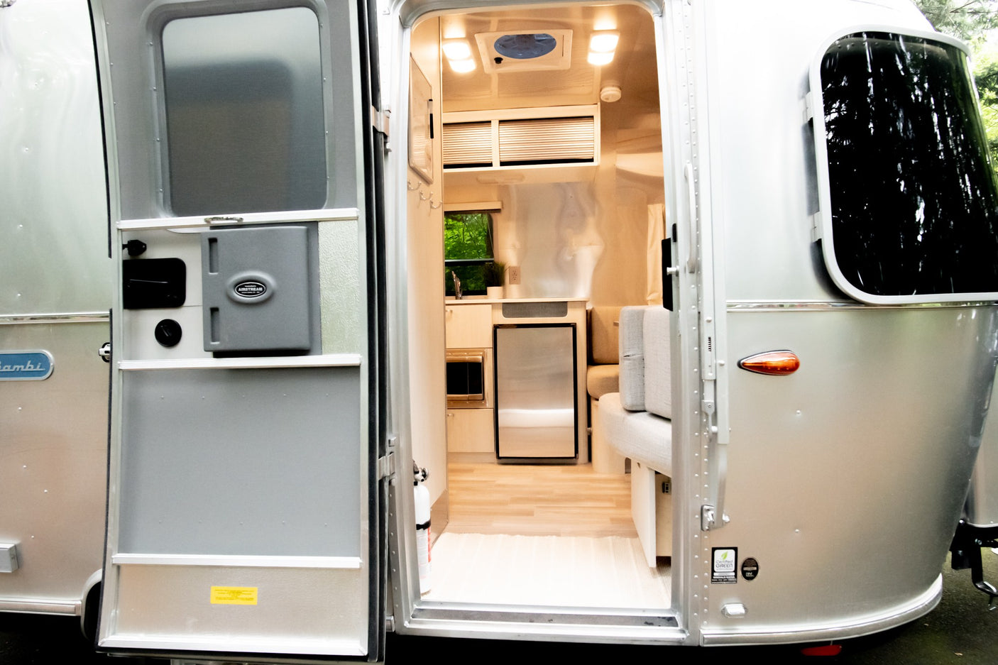 Open door of an Airstream Bambi RV rental, showcasing its modern silver exterior and compact, stylish interior.