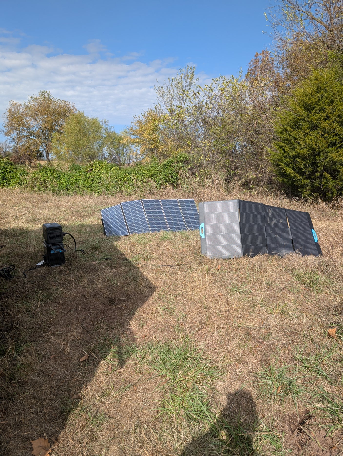 Powering your RV rental: Portable solar panels and a power station charging in a sunny, grassy field. Off-grid energy.