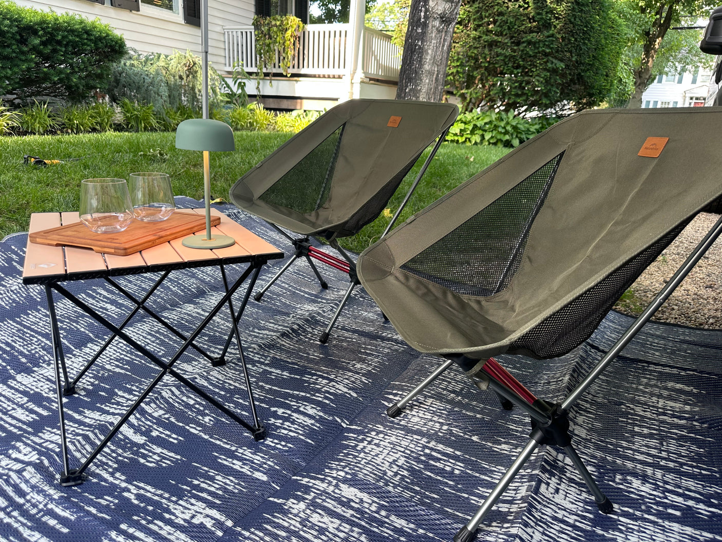 A cozy outdoor setup with portable chairs, table, and mat for your RV rental. Perfect for unwinding in nature.