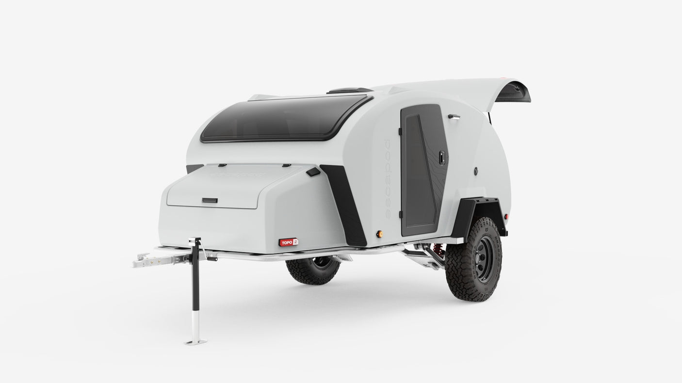 This sleek white teardrop off-road camper, perfect for an RV rental, features a large skylight and rugged tires for adventure.