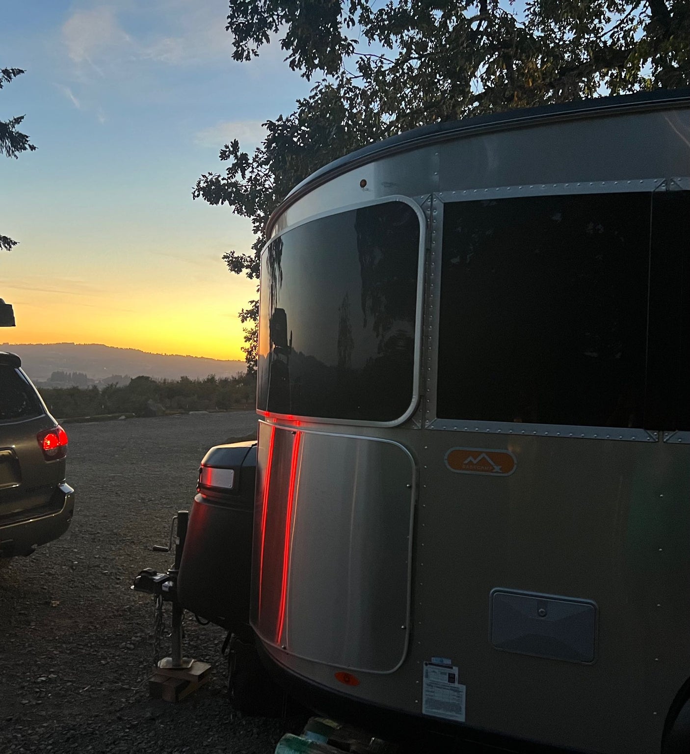 and a rear door with storage nets. Perfect for travel.|Compact RV rental interior featuring a kitchen with sink