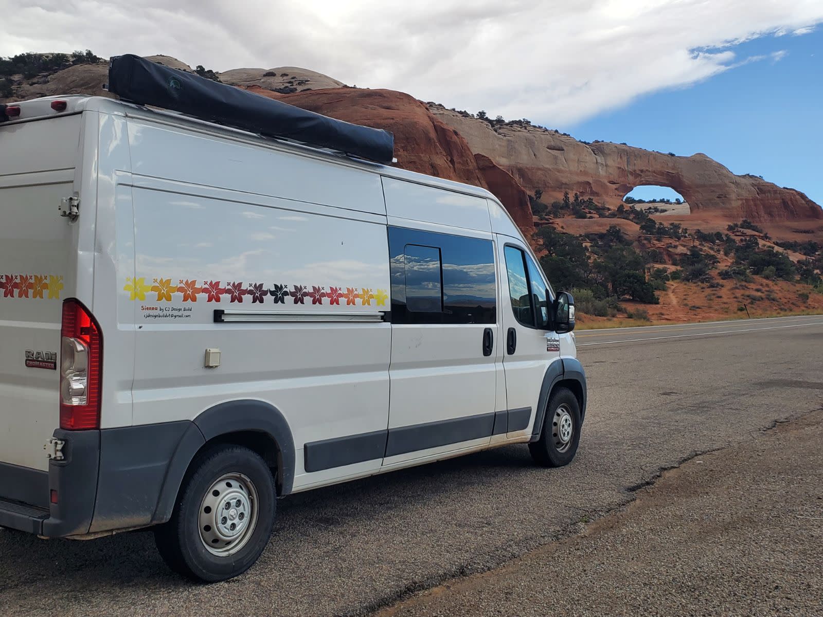 and a comfortable swiveling seat in a cozy camper van.|Open rear of an RV rental camper van