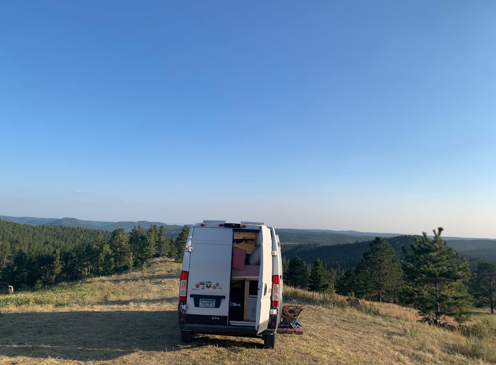 and water systems.|Open rear of an RV rental camper van shows a cozy bed