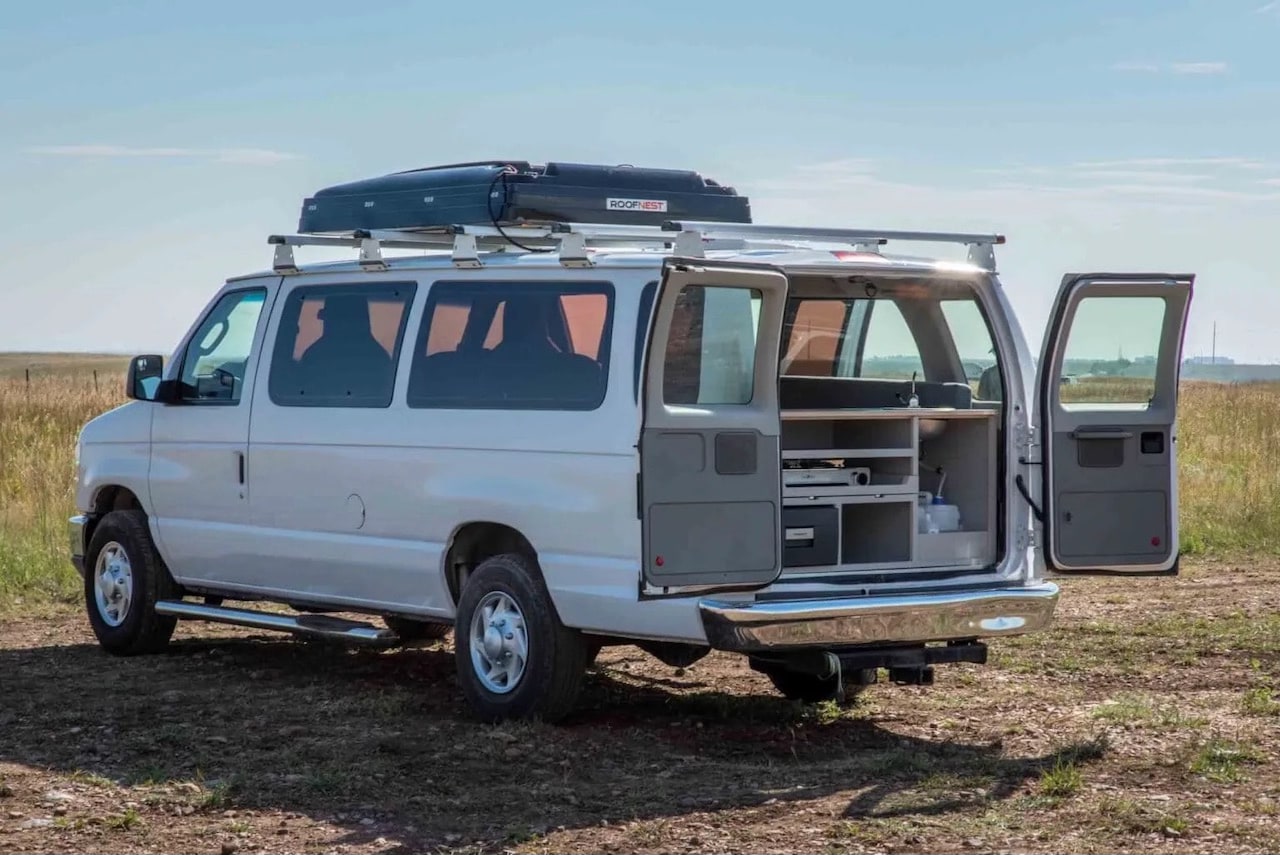 with a small sink visible at the rear.|Spacious rv rental interior with grey bed cushions — photo 16