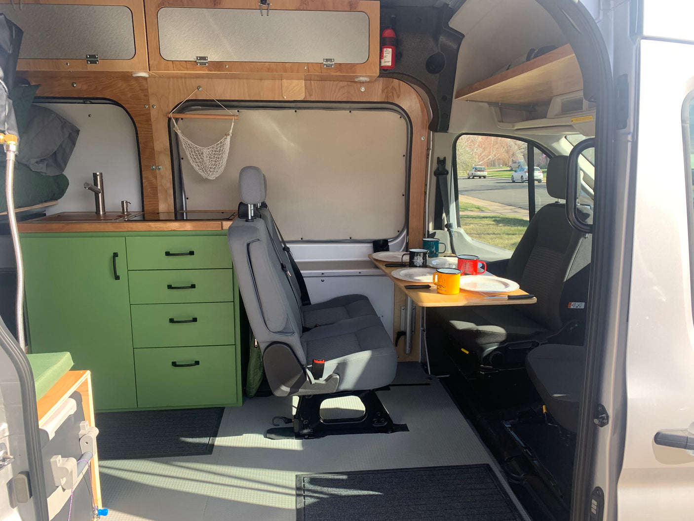 This RV rental's interior shows a smart camper van conversion with a kitchen, dinette, and ample storage.