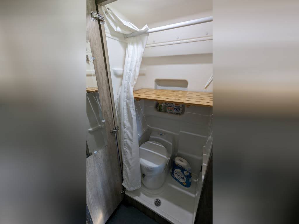 alongside a patterned bench seat.|Inside an RV rental: two cream-colored