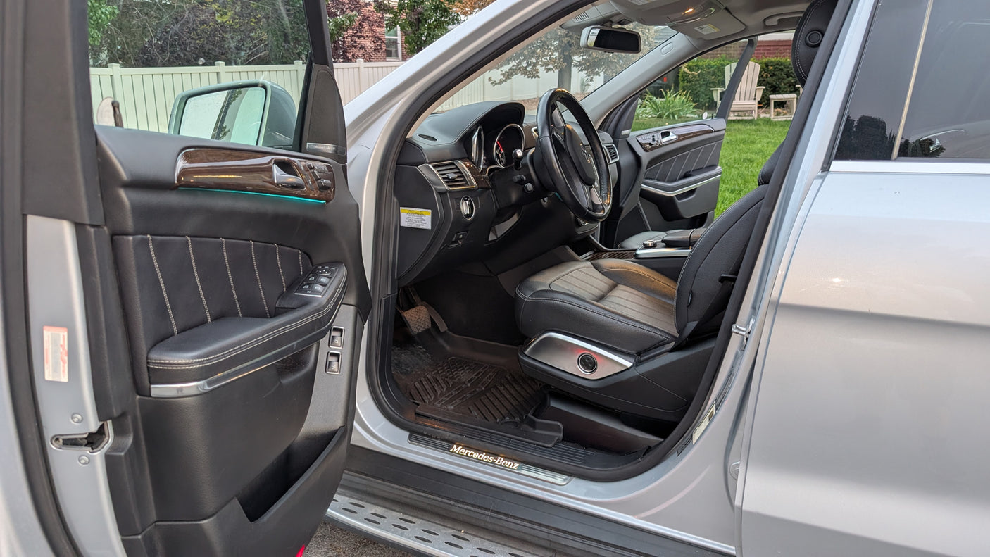 Detailed Mercedes-Benz SUV interior: black leather, wood trim, ambient light. Perfect for travel, even with your RV rental plans.