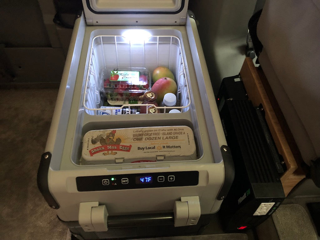 RV rental setup: A portable electric cooler with fresh produce (47F) and "Shaka Moa Eggs," powered by a PROwatt SW inverter.