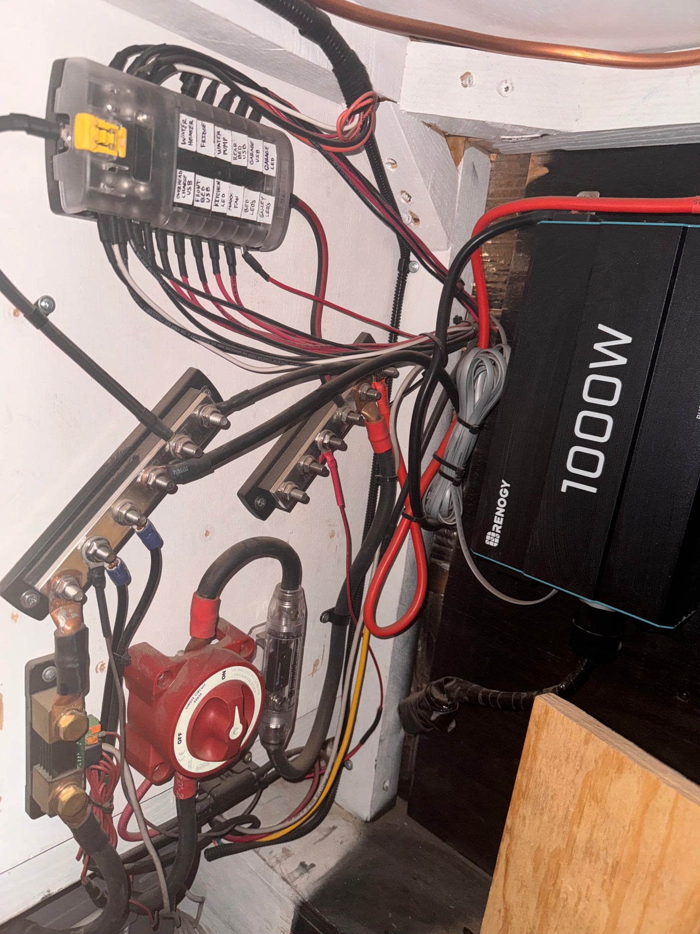 RV rental's intricate electrical system, featuring a Renogy 1000W inverter, fuse box, and wiring for onboard appliances.