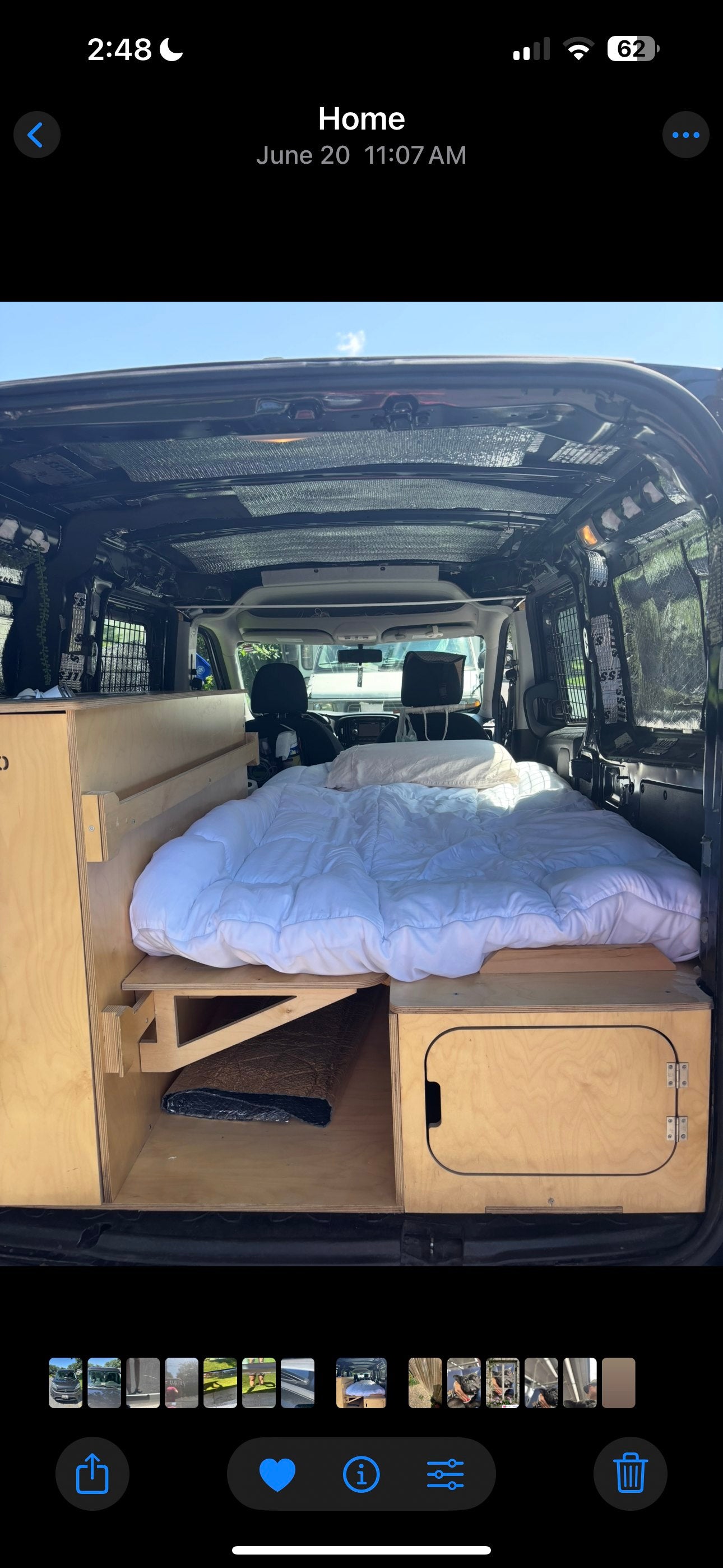Inside a customized RV rental van: a comfy bed and built-in wooden storage, perfect for road trips.