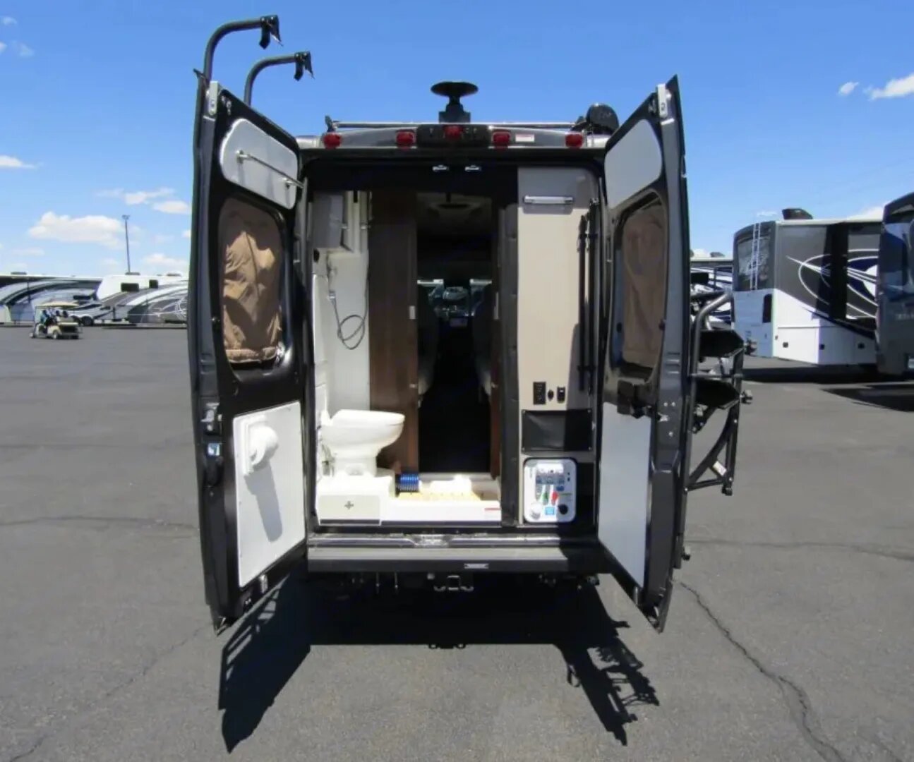 RV rental: The rear doors of this compact camper van open to reveal a small interior bathroom with a toilet and shower.