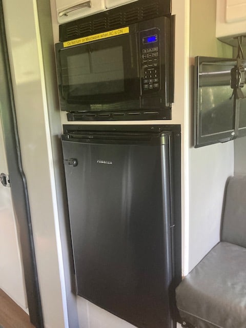 and seating.|Cozy RV rental dining booth: featuring a grey fabric backrest