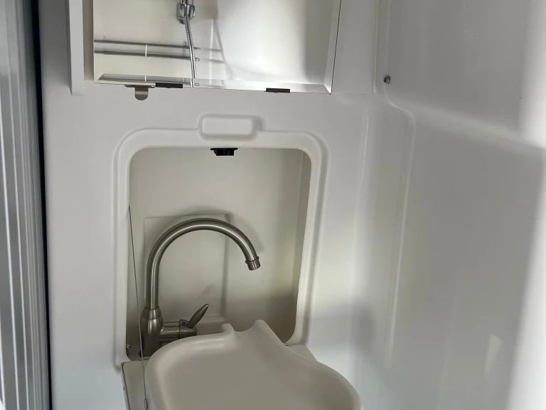 RV rental's compact wet bath features an integrated sink, faucet, and overhead shower.