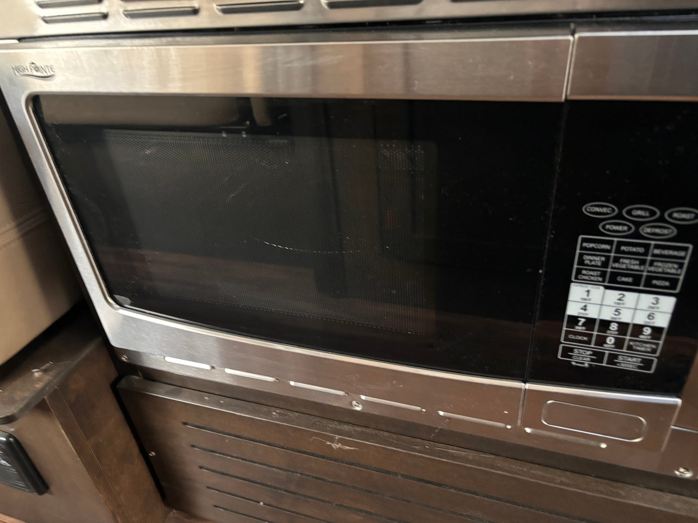 Compact stainless steel High Pointe microwave, ideal for an RV rental, featuring a convection oven and full control panel.