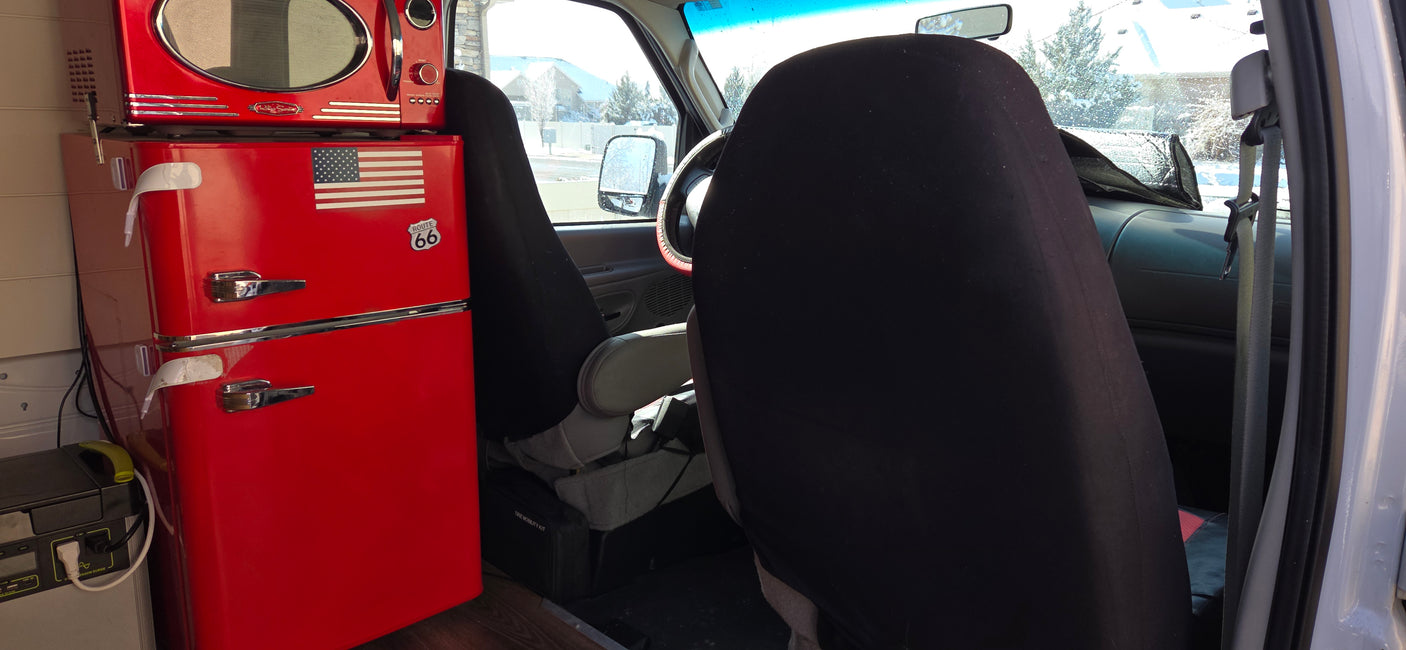 Retro red microwave & mini-fridge with power station in an RV rental. A compact mobile kitchen setup for van life!