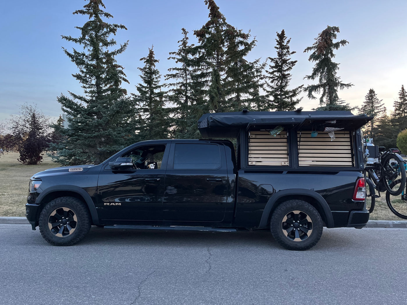 Black Ram truck with custom slat-sided camper and bike rack. Perfect rv rental for outdoor adventure. — photo 19