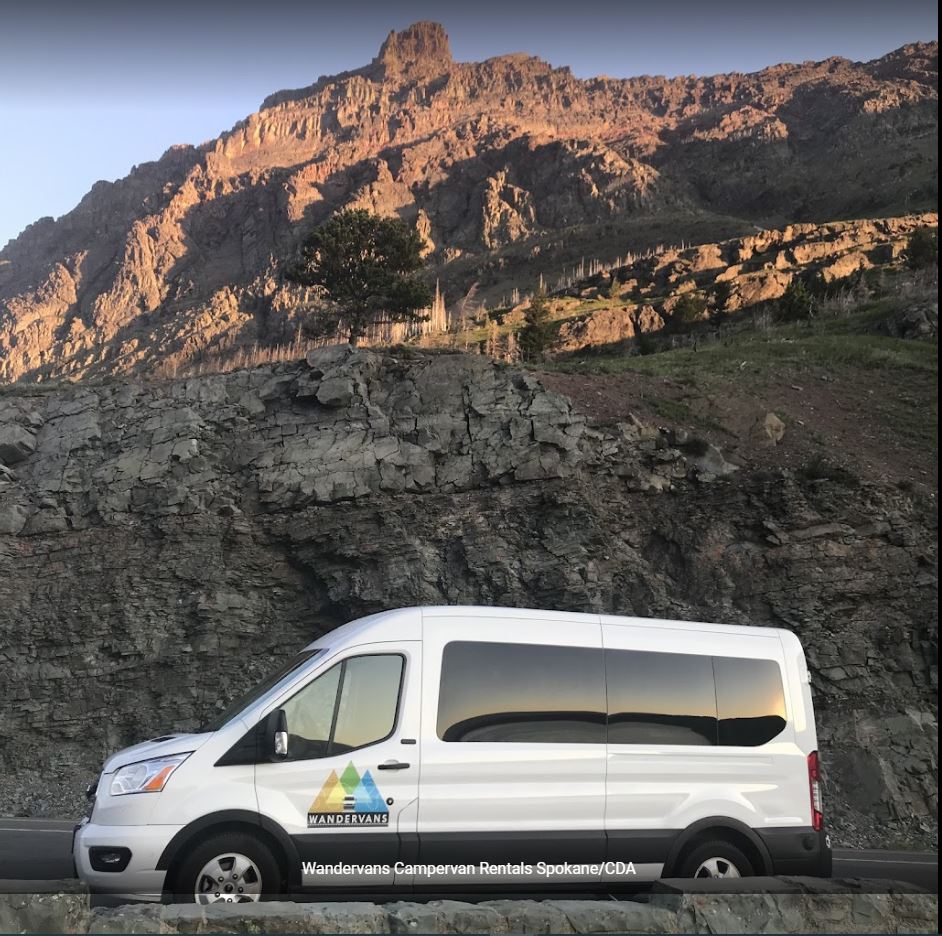 fronting sunlit rocky mountains.|White Wandervans campervan for RV rental