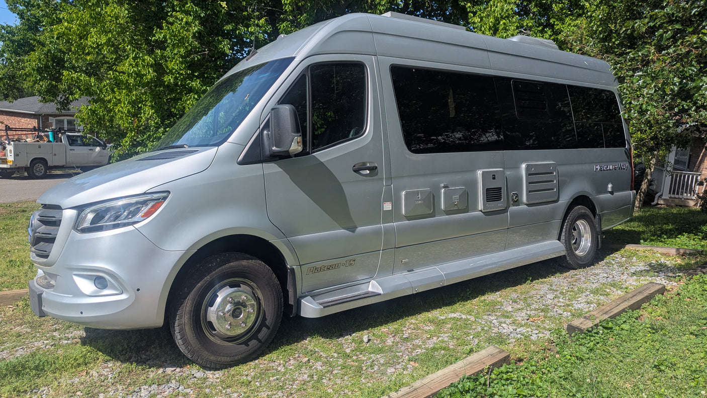 Silver Pleasure-Way Plateau TS RV rental, a Mercedes Sprinter camper van, parked outdoors on a sunny day.