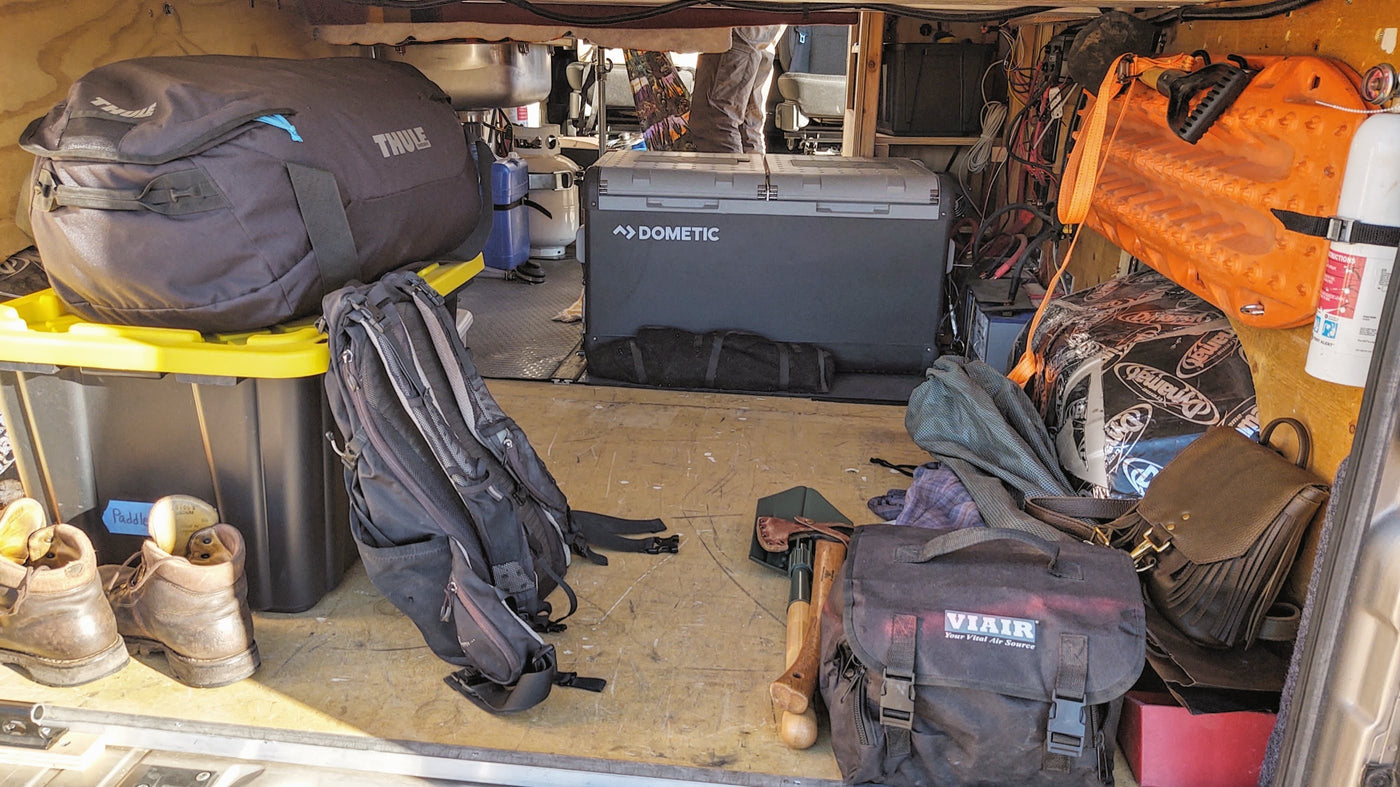 gear & dog bowl for a desert adventure.|RV rental interior shows a compact kitchen with a red portable stove — photo 6