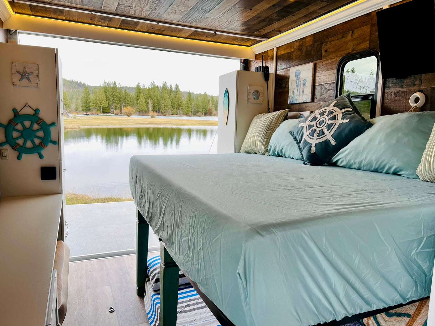 RV rental: inviting bedroom with nautical decor, comfy bed, and a stunning panoramic lake view.