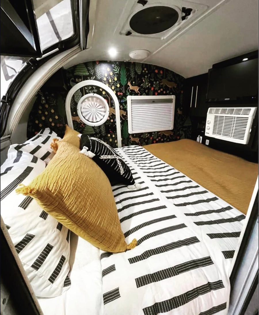 showing a bed & patterned door. Black & white rug out front