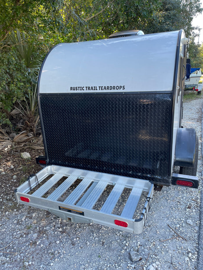 silver and black teardrop trailer with a rear cargo carrier for your gear.|RV rental interior: A gray