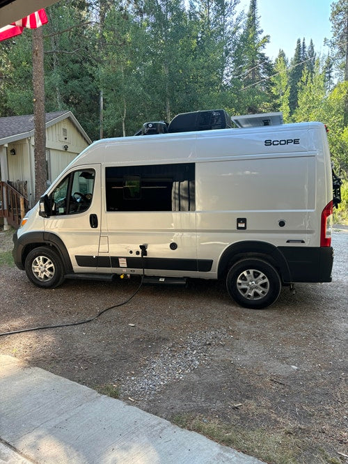 and a scenic forest view outside a home.|Looking forward inside a sleek rv rental camper van