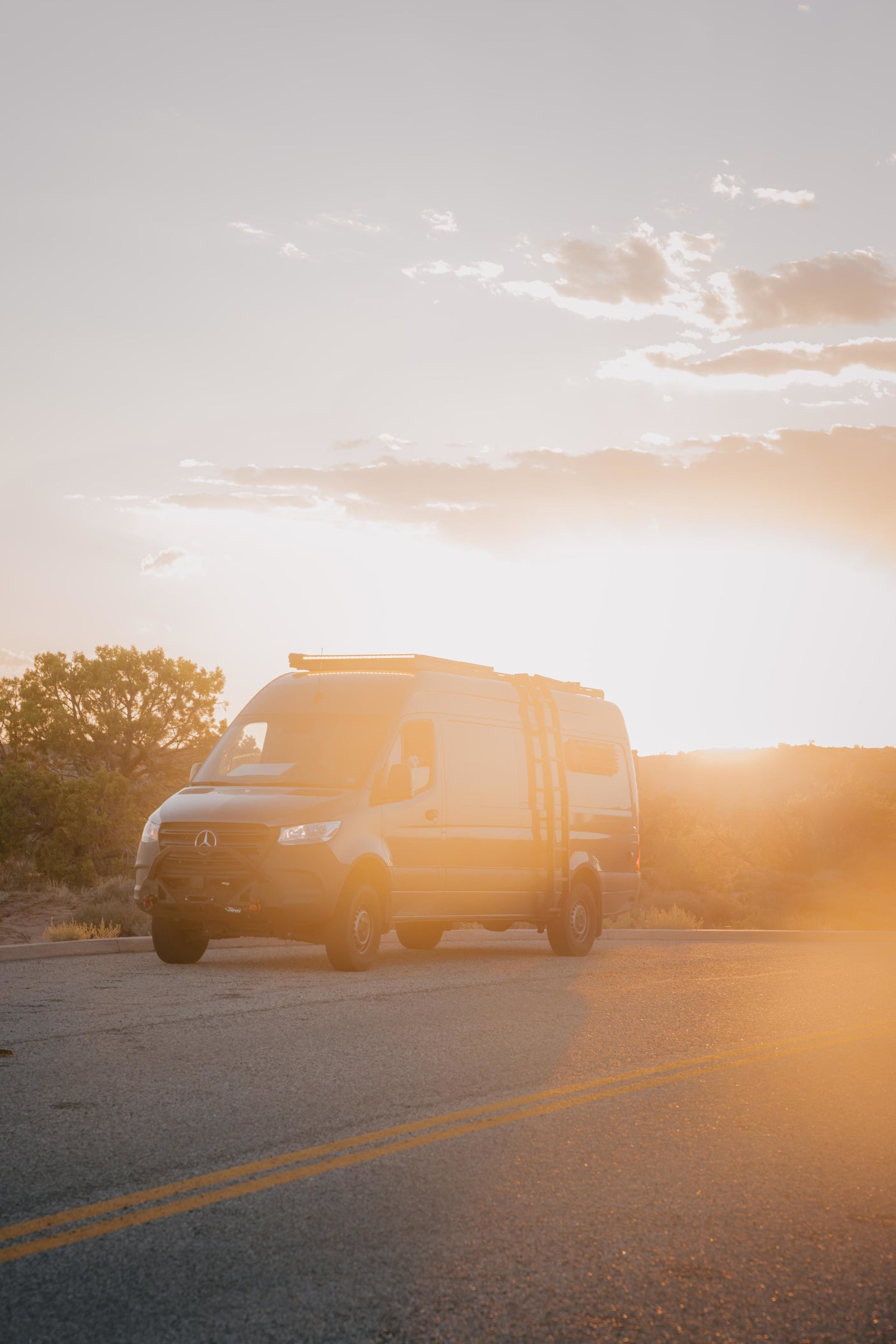 parked on a desert road at sunset.|A person sits inside this Mercedes Sprinter rv rental