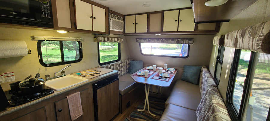 Step inside this cozy rv rental! Features a fully-equipped kitchen, dining booth, and ample storage for your travels.