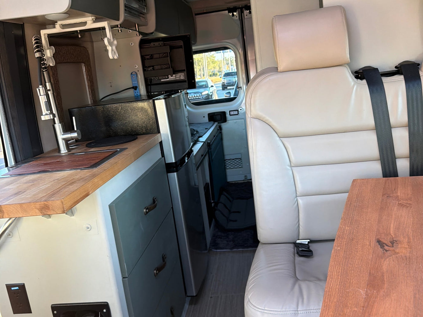 parked under sunny skies with palm trees. Ready for adventure!|Inside an RV rental: two-tone brown & black custom quilted seats — photo 4